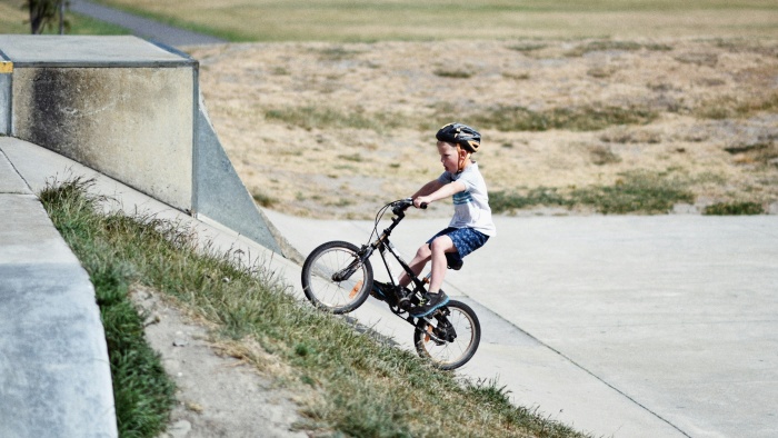 a kid wears helmet to ride the bike